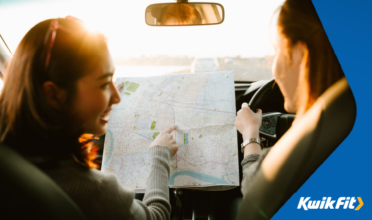 friends in a car using a map to navigate