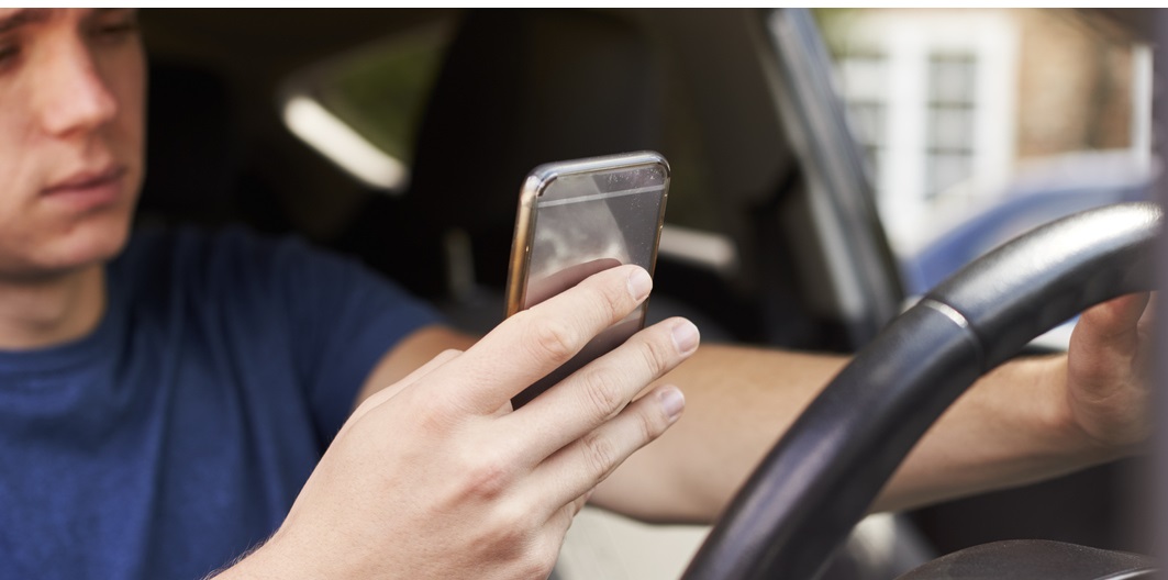 Man on mobile phone behind wheel